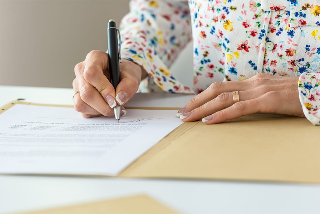 wasserschaden-versicherung-unterlagen-ausfuellen-goettingen Frau füllt handschriftlich Versicherungsunterlagen aus nach Wasserschaden durch undichtes Dach in Göttingen